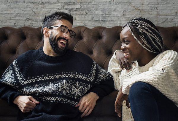 couple laughing together on leather sofa