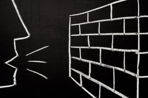 chalkboard drawing of person talking to brick wall