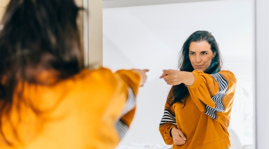 woman pointing at herself confidently in the mirror