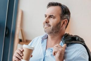 man looking relaxed holding cup of coffee
