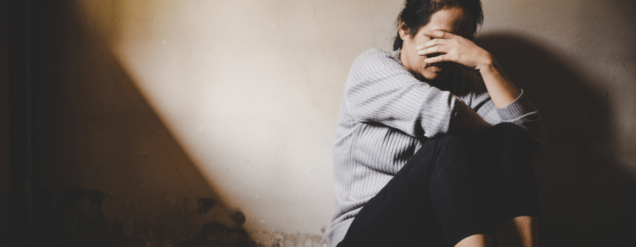 Woman sitting with hand covering face