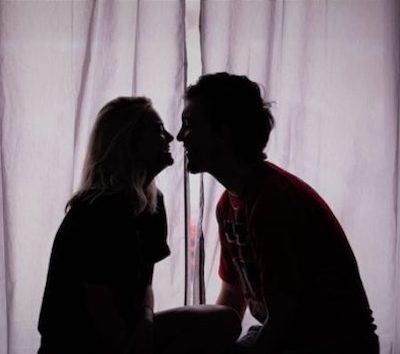 Couple looking intimately at each other in darkened room