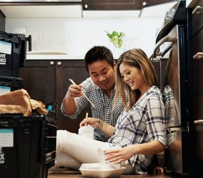 couple sitting on floor eating takeaway together