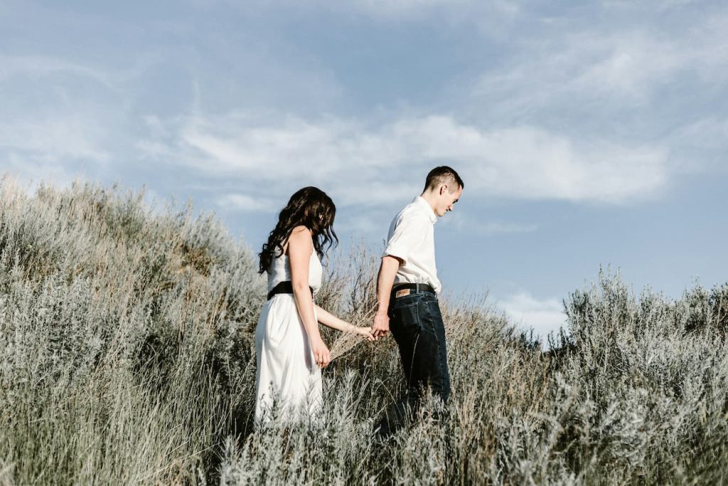 couple-walks-of-grassy-field