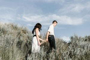 couple-walks-of-grassy-field