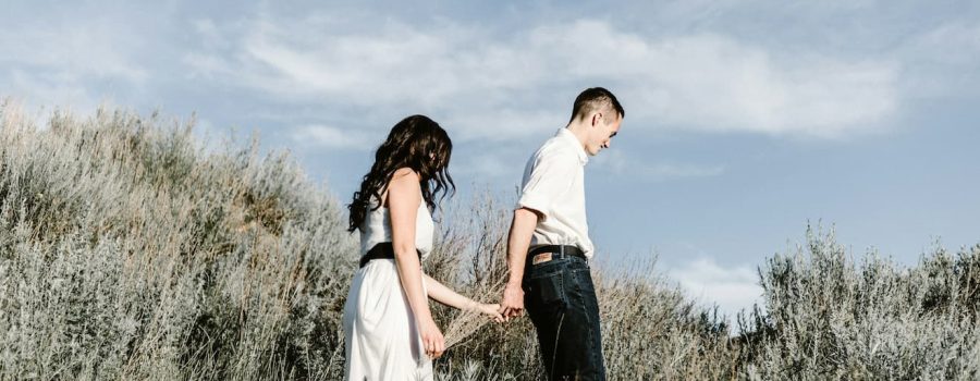 couple-walks-of-grassy-field