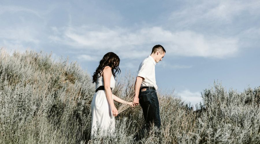 couple-walks-of-grassy-field